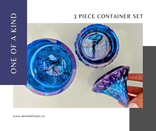 three piece container set in blue, purple, white and a hint of sparkle. Featuring humming birds in the bottom of each dish. One is an open barrel style container and theother is a a teardrop shape lid on a shallow dish.