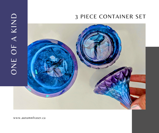 three piece container set in blue, purple, white and a hint of sparkle. Featuring humming birds in the bottom of each dish. One is an open barrel style container and theother is a a teardrop shape lid on a shallow dish. 