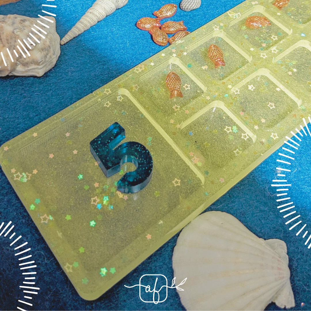 4 different 10 Frames made with resin and including tiny sparkles. One each of slightly see-through green, yellow, pink and red. Shown with tiny felt hearts as the counters and shiny resin numbers
